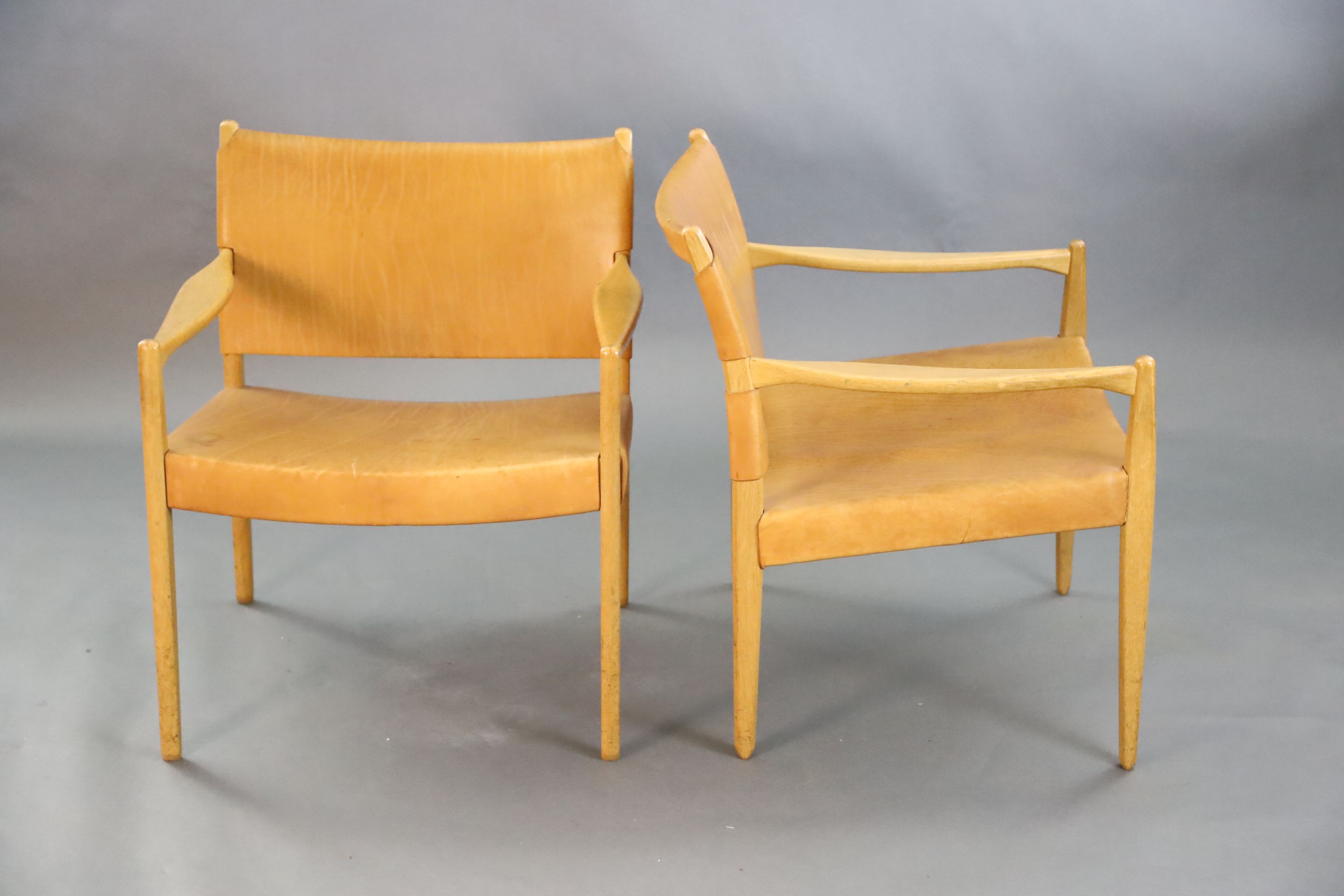 A pair of Swedish Varufakta tan leather and golden oak armchairs, W.2ft 1in. D. 2ft 1in. H.2ft 4in.